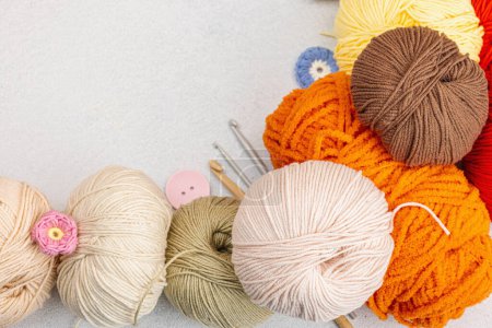 A set of colorful clew of thread for knitting and special craft tools. Handmade, hobby, crochet concept. Props and stuff on light stone concrete background, top view