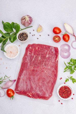 Photo for Dry aged Bavette steak with traditional spices and herbs. Fresh raw meat cut, light stone concrete background, flat lay, top view - Royalty Free Image