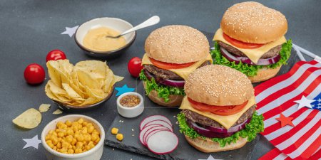 Photo for Homemade burgers. An American classic, traditional food for picnic, party or celebration Independence Day. Sauce, chips, sweet corn. Dark stone concrete background, banner format - Royalty Free Image