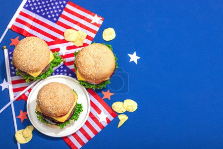 Photo for Homemade burgers. An American classic, traditional food for picnic, party or celebration Independence Day. Hard light, dark shadow, flat lay, blue background, top view - Royalty Free Image