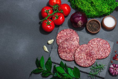 Photo for Raw burger patties. Fresh meat cutlets, spices, vegetables and herbs. Homemade American classic, traditional food for picnic, party or Independence Day. Dark stone concrete background, top view - Royalty Free Image