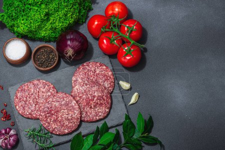 Photo for Raw burger patties. Fresh meat cutlets, spices, vegetables and herbs. Homemade American classic, traditional food for picnic, party or Independence Day. Dark stone concrete background, top view - Royalty Free Image