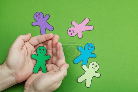 Photo for World mental health day. Male hands holding paper men figures with different emotions. Feedback rating, customer review, experience, satisfaction survey or assessment concept, flat lay - Royalty Free Image