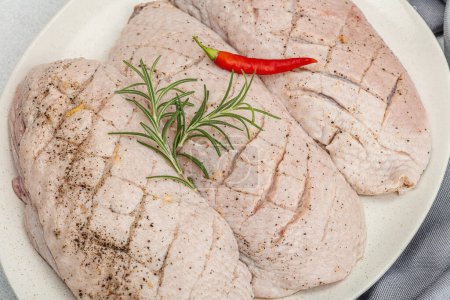 Photo for Raw duck breast with fresh spices and herbs, ready to cook food. Domestic tasty cuisine, poultry meat fillet. Light stone concrete background, close up - Royalty Free Image