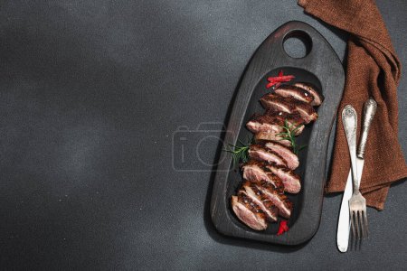 Photo for Fried duck breast with fresh orange and ginger, ready to eat food. Domestic tasty cuisine, poultry meat fillet. Dark stone concrete background, top view - Royalty Free Image
