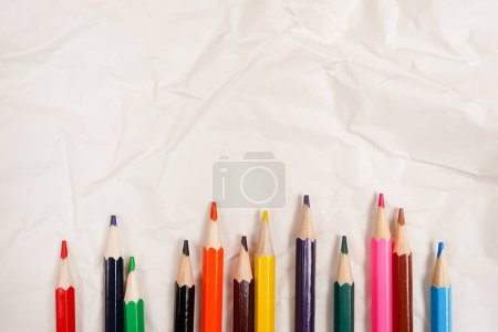 Foto de Colored Pencils for School on Crumpled white paper background - Imagen libre de derechos