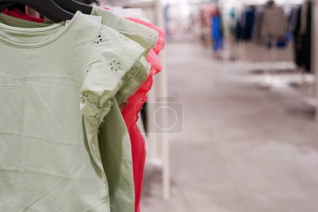 Téléchargez les photos : Vêtements pour enfants suspendus aux cintres dans la boutique - en image libre de droit