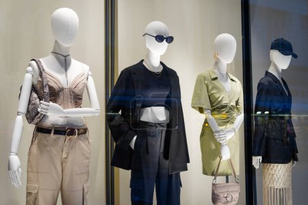 Téléchargez les photos : Quatre mannequins dans la vitrine élégante de magasin de vêtements - en image libre de droit