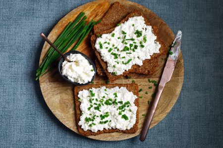 Open sandwiches with rye bread and white cottage cheese with green onions. Healthy breakfast or snack.