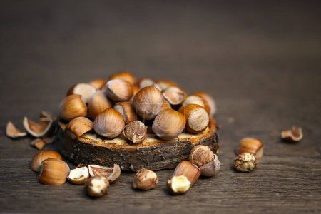 Close-up. Hazelnuts in shell and without on a wooden stand.