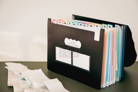 12-Month Accordion File Organizer, Monthly Document Filing System with Color-Coded Tabs for Home Office and a Stack of Receipts for Tax Filing, January to December Tabs