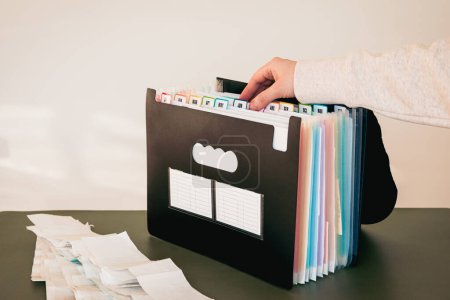 Woman Organizing Documents in a 12-Month Accordion File Organizer, Monthly Filing System with Color-Coded Tabs, Home Office, Receipts for Tax Filing, January to December Tabs