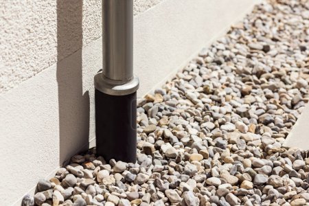 Drain pipe or Sewer install in French drain under Stones Floor or Drain Gravel Cover, Modern Water Drainage System near House Foundation. To collect Stormwater from downspout outlet, storm gutter.