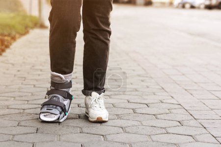 Photo for Ankle Orthosis or Brace on Woman Leg walking on Street. Ankle foot orthosis Shoes - Royalty Free Image