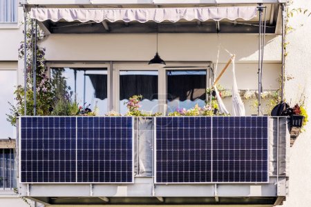 Téléchargez les photos : Panneau solaire sur le balcon de l'immeuble moderne. Balcon moderne avec panneaux solaires, marquise et jardin - en image libre de droit