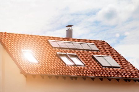 Téléchargez les photos : Lucarnes fenêtres avec volets roulants sur le toit du Mansard, lucarnes avec stores de protection solaire dans le grenier de tuiles rouges - en image libre de droit