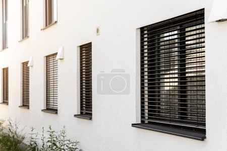 Roller Blinds on Windows of Modern House. Window with Shutter Outside. 