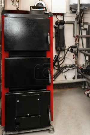 Foto de Solid-fuel Boiler with Heating System Equipment in Boiler room. Close up. - Imagen libre de derechos