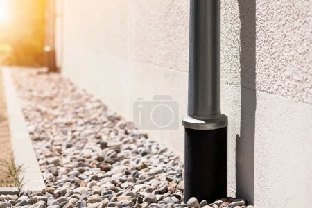 Photo for French Drain and Downspout. Drainage System Floor around House. Sewage pipe in Drain Stones Pebble. - Royalty Free Image