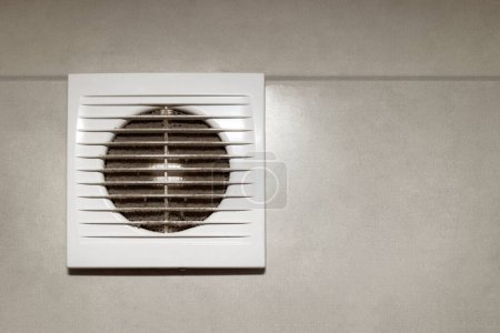 Ventilador de aire con rejilla de plástico blanco con polvo, espacio de copia. Capa de polvo en la rejilla de ventilación