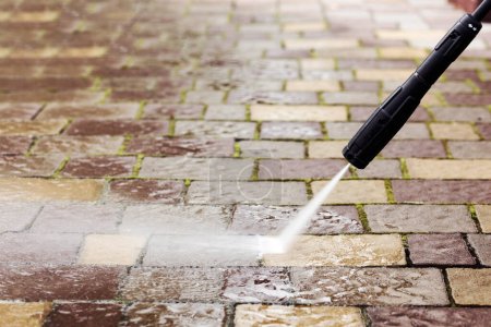 Cleaning Pavement Paving Stones with High Pressure Washer. Copy Space. Spring Professional Pressure Cleaning Service concept.