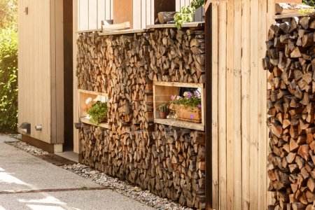 Stockage de bois de chauffage empilé est mur de décoration de jardin patio dans la cour communautaire. Cheminée en bois de chauffage dans un design moderne.