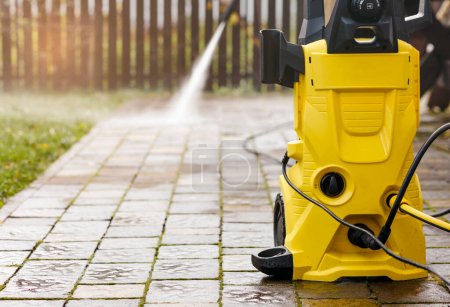 Téléchargez les photos : Nettoyage sous pression avec Karcher laveuse haute pression dans Garden Park ou Street Cleaning Service - en image libre de droit