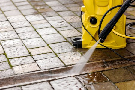 Photo for Cleaning dirty block Pavement Paving Stones and Concrete Gutter with Water jet from High Pressure Washer. Copy space. High Pressure Cleaning Service. - Royalty Free Image