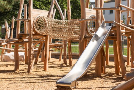 Photo for Children Playground with Modern Slide, Rope Net Bridge, Climbing Swings, Climbers. Empty Wooden Playground made of Eco Materials - Wooden Tree trunk Logs Robinia. - Royalty Free Image