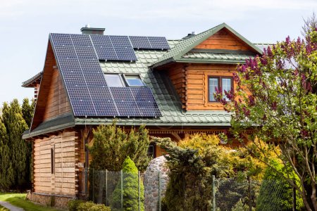 Foto de Paneles solares en el tejado de la antigua casa de madera en el campo. Azotea de Mansard con Skylight Windows y sistema de panel solar. - Imagen libre de derechos