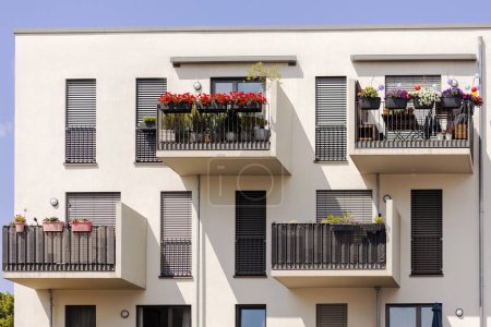 Téléchargez les photos : Façade de balcon de l'immeuble d'appartements moderne. les fleurs du jardin sur les balcons en Europe. - en image libre de droit