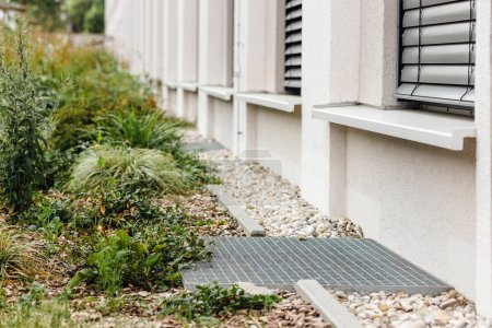 Water Drainage along Perimeter Building French Drain System Pebbles for Rainwater with Drain Grate
