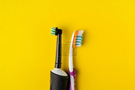 Photo for Electric and manual toothbrushes on a yellow background. - Royalty Free Image
