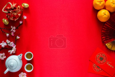 Photo for Chinese new year background concept with tea set, ingots(word means wealth), red bag, oranges and red envelope packets or ang bao(word means blessing and 5 blessing) on red satin cloth background. - Royalty Free Image