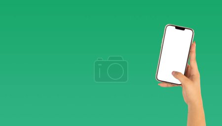 Téléchargez les photos : Main d'une belle femme tenant un téléphone portable avec écran blanc sur fond vert - en image libre de droit