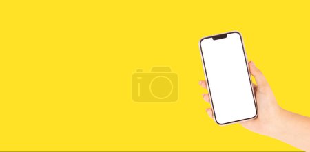 Photo for Beautiful hand of a woman holding a cell phone on bright yellow background - Royalty Free Image