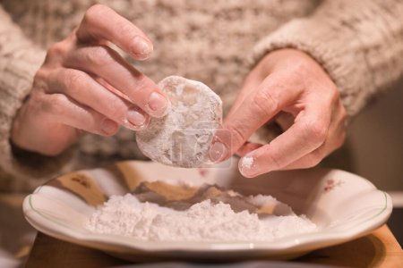 Foto de Wrapping of Masaryk cookies - christmas sweets in powder sugar after baking - Imagen libre de derechos