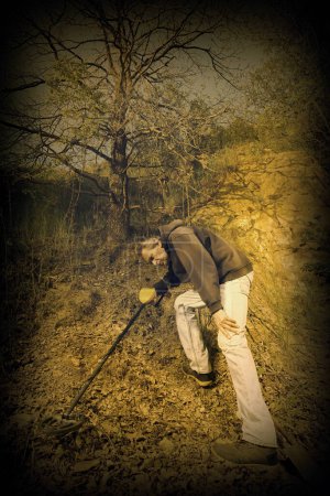 Photo for Adventurer with metal detector found a WW2 deposit of German gold - Royalty Free Image