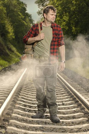 Photo for Adventurer with retro haversack wandering nature on railroad way - Royalty Free Image