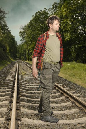 Téléchargez les photos : Aventurier avec haversack rétro nature errante sur le chemin de fer - en image libre de droit