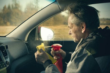 Foto de Hombre mayor cuidar annd limpieza interior del coche en el aparcamiento de la naturaleza - Imagen libre de derechos