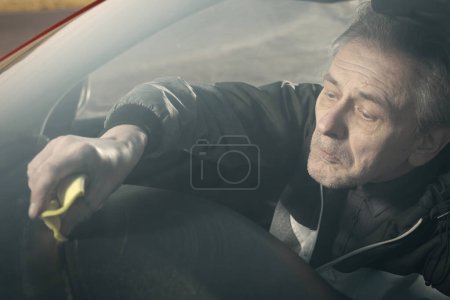 Photo for Older man take care annd cleaning car interior on nature parking - Royalty Free Image
