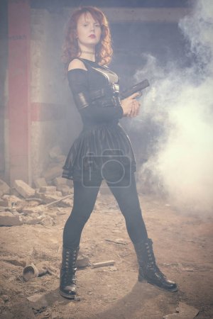 Photo for Fighter lady observing and looking around in ruins of building - Royalty Free Image