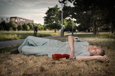 Téléchargez les photos : Vieil homme accro ivre dans le parc de la ville d'été incapable de marcher - en image libre de droit
