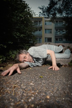 Foto de Viejo adicto borracho en el parque de la ciudad de verano incapaz de caminar - Imagen libre de derechos