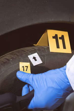 Foto de Investigación de la escena del crimen: recogida de pruebas de muestras de suelo en la rueda del automóvil - Imagen libre de derechos