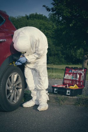 Foto de Investigación de la escena del crimen: recogida de pruebas de muestras de suelo en la rueda del automóvil - Imagen libre de derechos