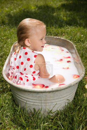 Photo for Little girl enjoying bath in retro metal sheet bath tub in park - Royalty Free Image