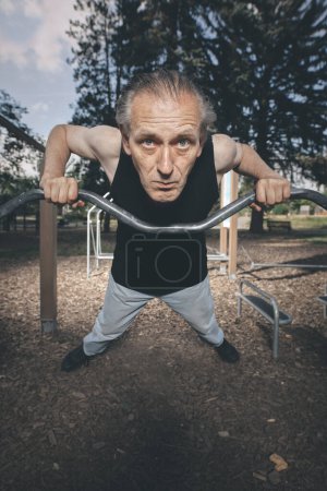 Téléchargez les photos : Laide homme de mauvaise condition essayant séance d'entraînement dans la salle de gym extérieure - en image libre de droit