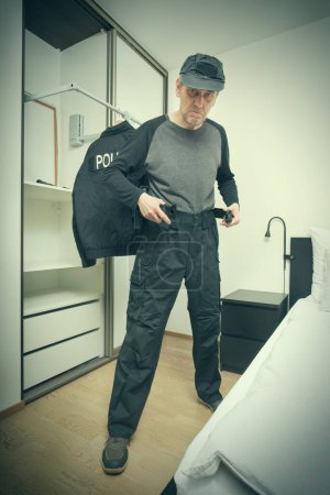 Foto de Mayor delgado policía de la ciudad vestirse en el dormitorio para el servicio - Imagen libre de derechos